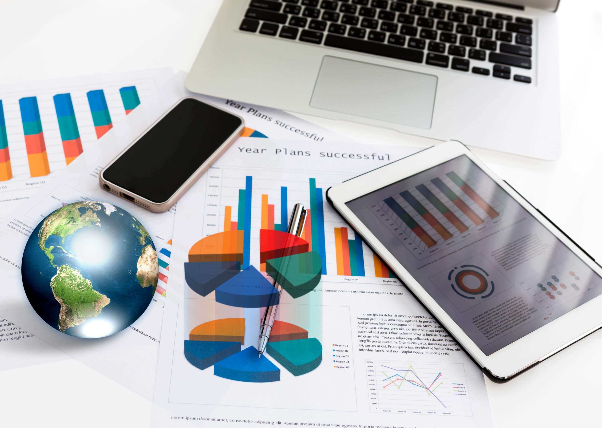 Financial charts on the table with tablet phone and pen  (Elements of this image furnished by NASA)